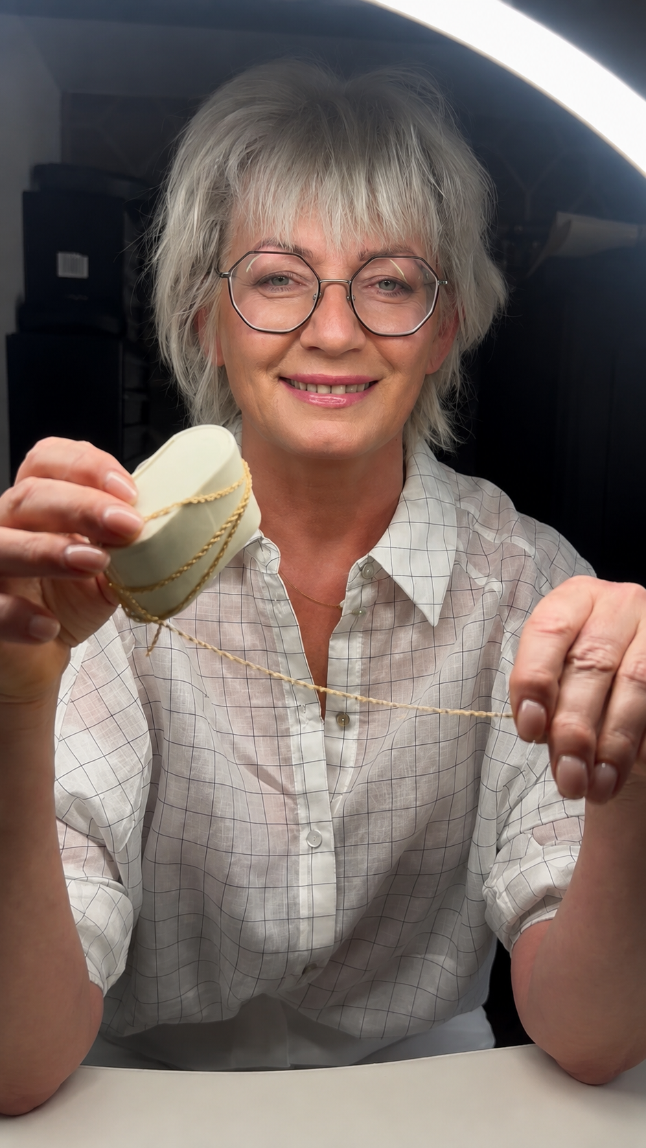 Kasia, founder of PearlStone.Art, holding a gold permanent jewellery chain
